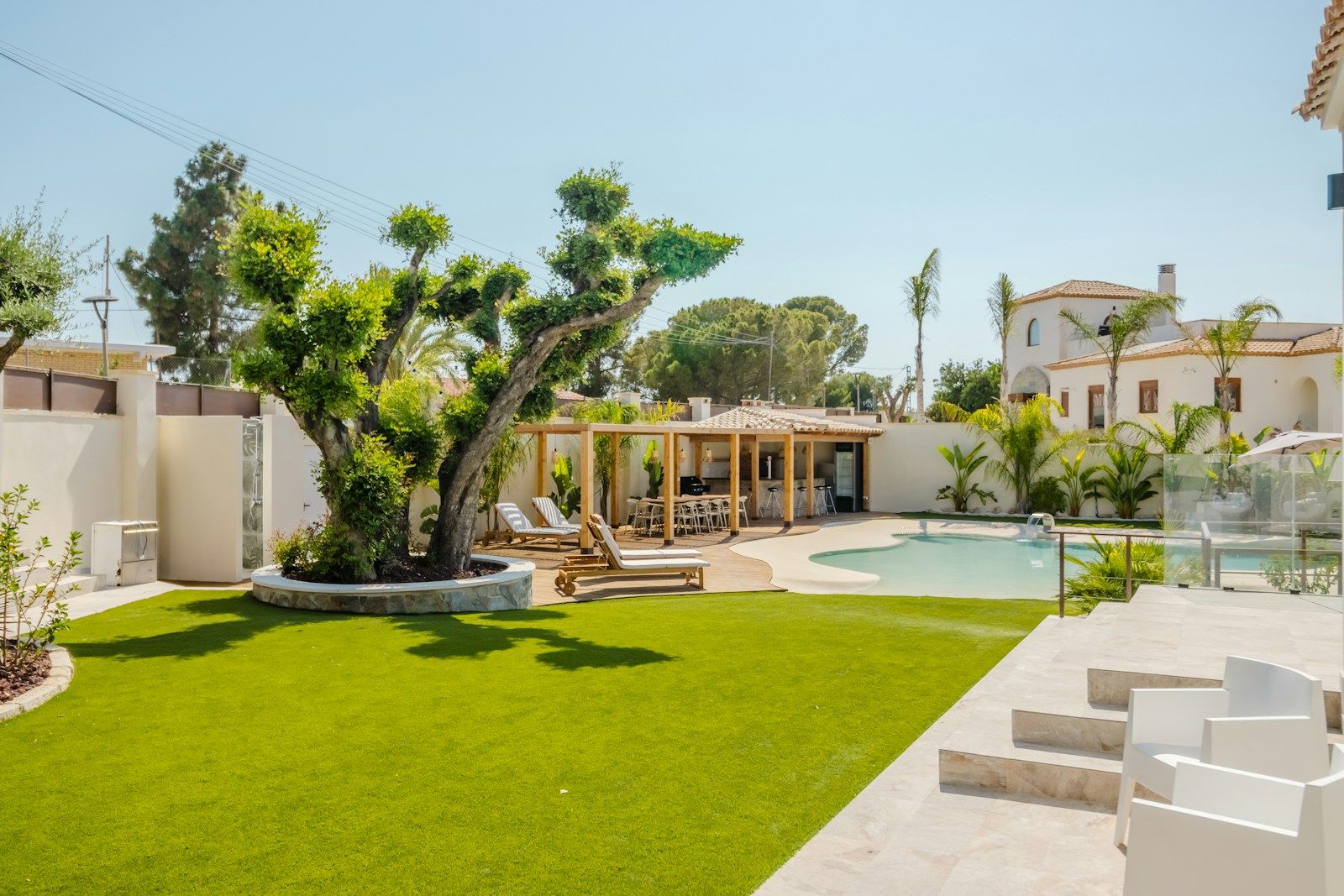 Backyard with lawn, pergola lounge area and pool — design inspiration (stock photo)
